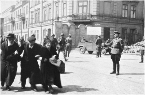 Three elderly Jews walk arm-in-arm through the streets of Krakow during the final liquidation action of the ghetto.jpg